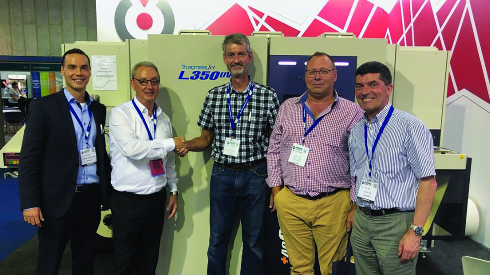 Sullwald Printing Solutions owner Marius Sullwald shaking hands with Rotocon CEO Michael Aengenvoort, in front of a Truepress Jet L350UV.