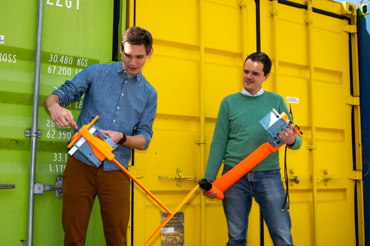Photo of two Flying Fish Engineers holding hydrofoil test equipment.