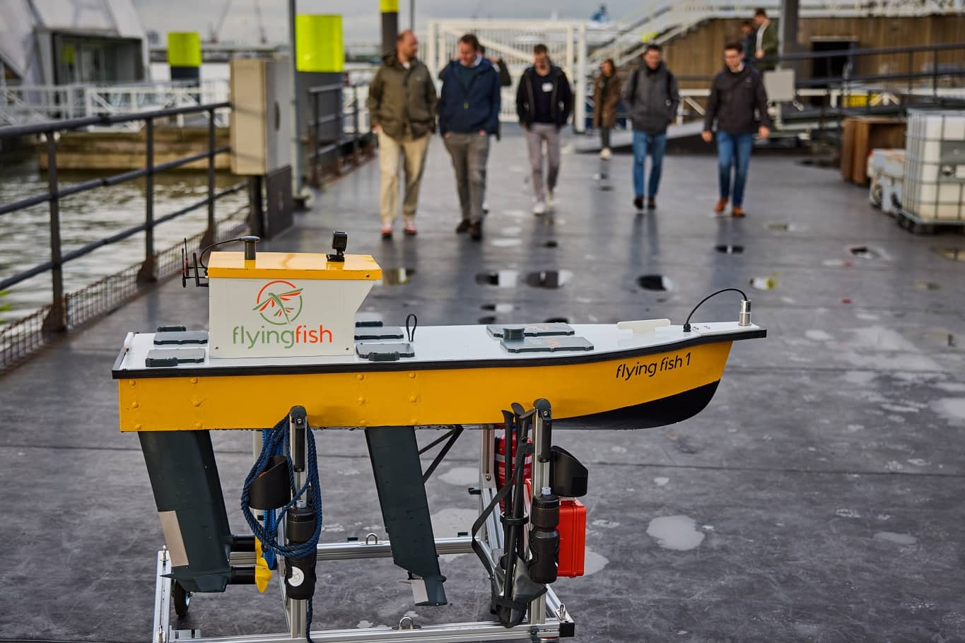 Picture of the Flying Fish 1 hydrofoil demonstrator boat, with Flying Fish engineers walking towards it.