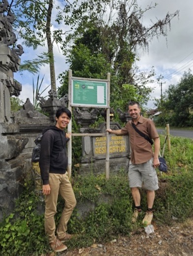 People stand by a sign showing the project information