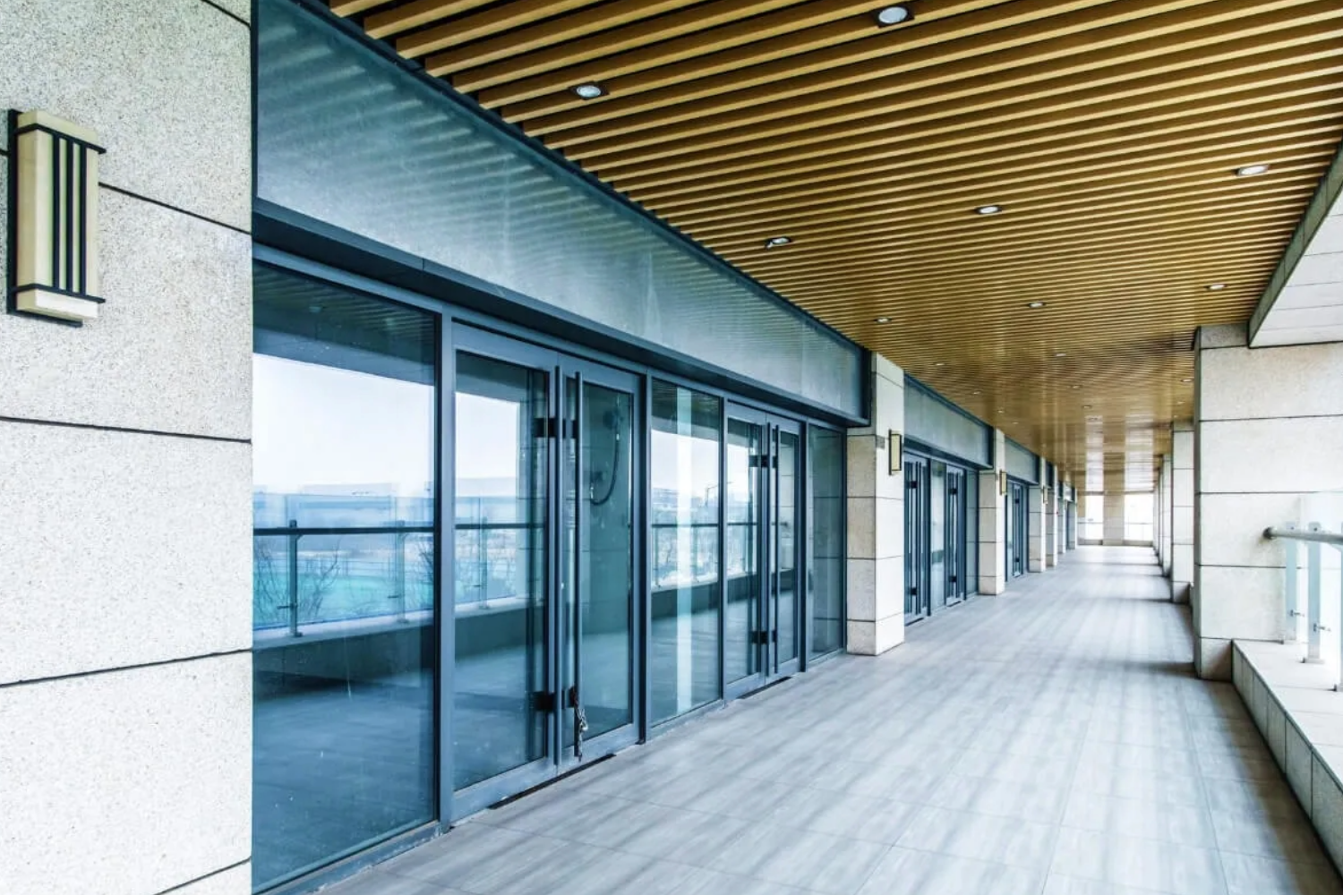 Modern patio with glass doors and wooden ceiling.