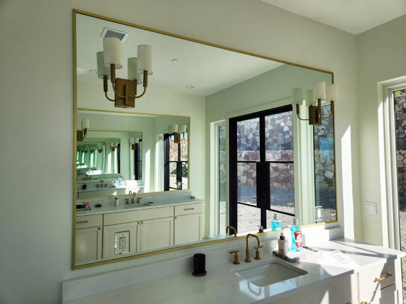 Bathroom with large mirror reflecting outdoor view.
