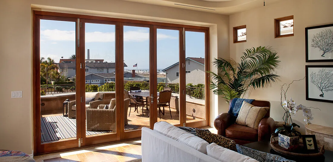 Living room with large wooden-framed glass doors opening to patio.
