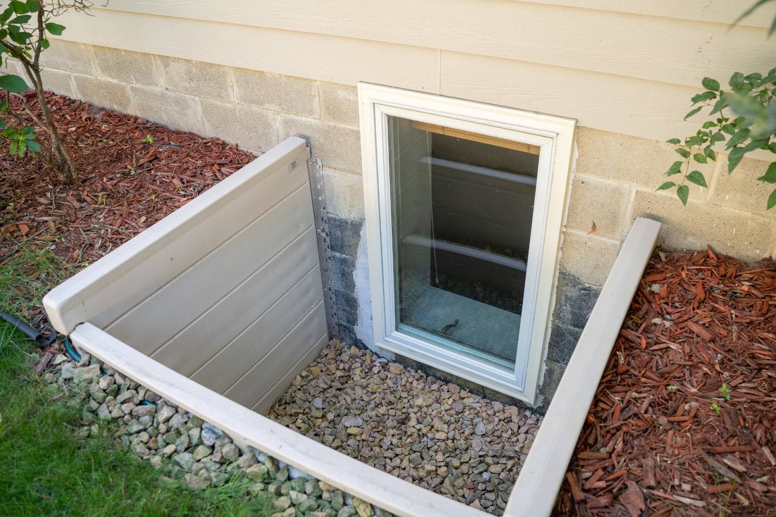 Basement window well with gravel.
