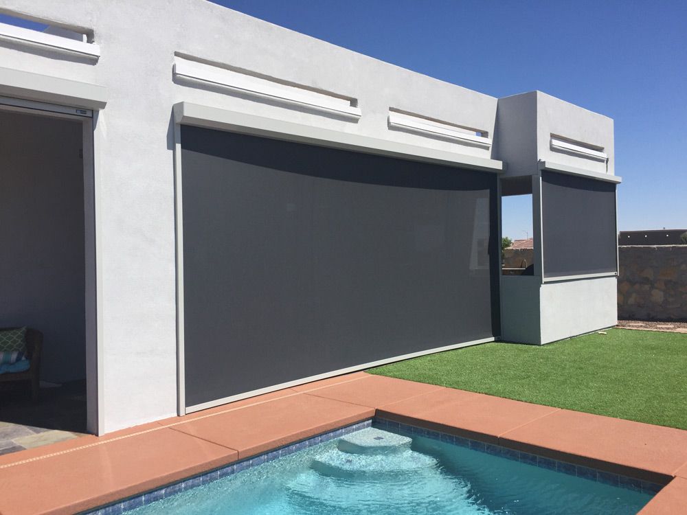 Motorized patio screens on modern house by pool