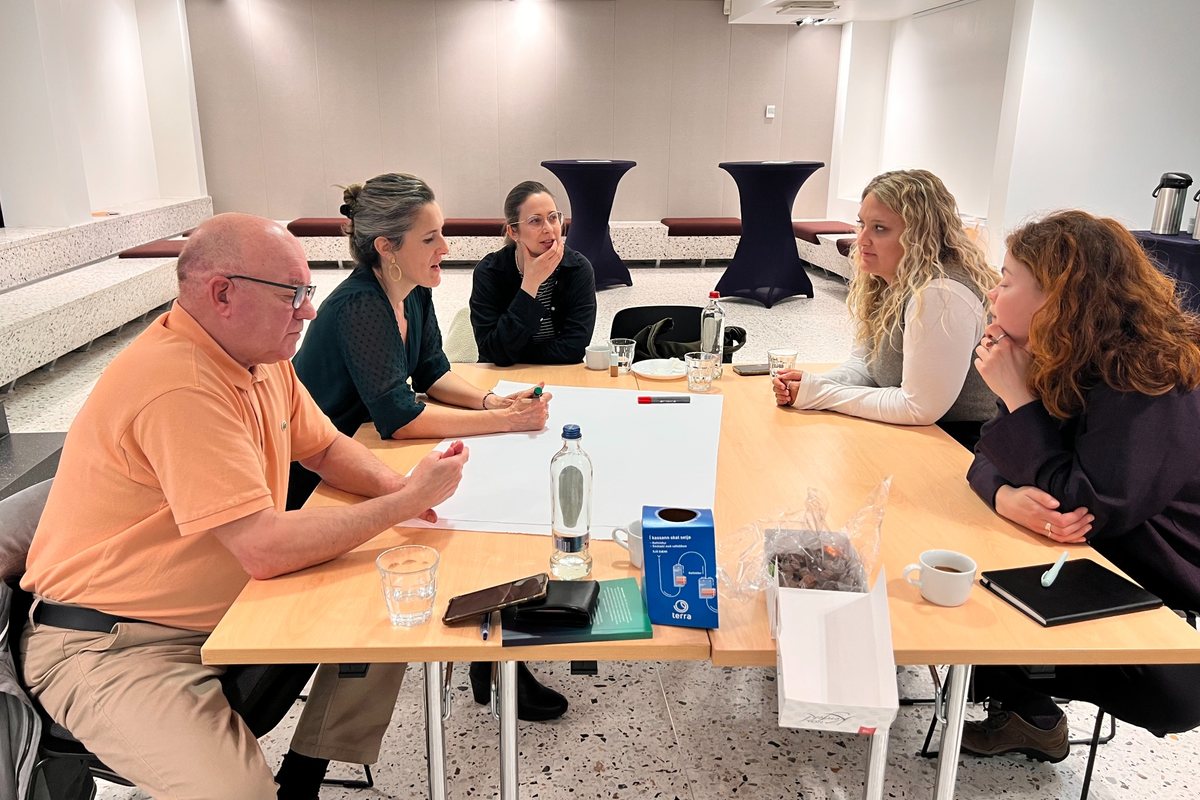International participants collaborating around a workshop table