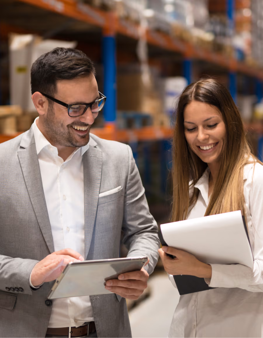 Two professionals discussing on a tablet in a warehouse