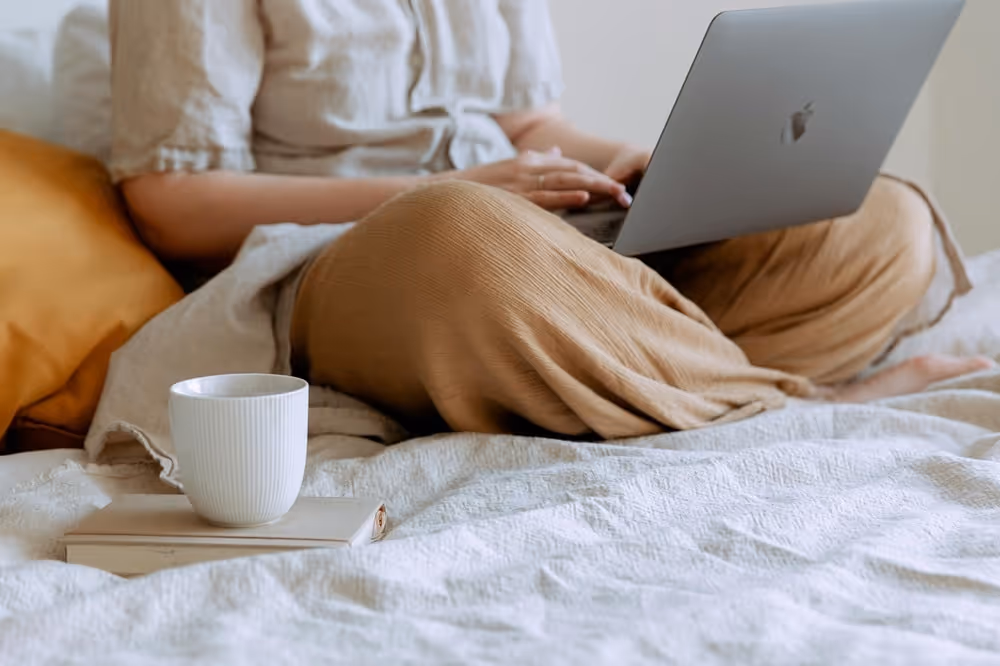 Person sitting and working on a MacBook placed on their lap