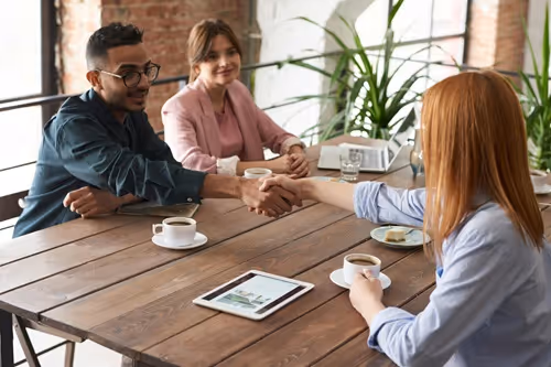 Client onboarding with a handshake of two parties sitting at table