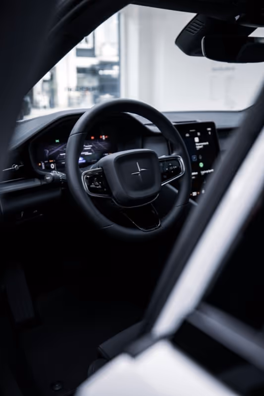 The interior of a car with a steering wheel and dashboard.