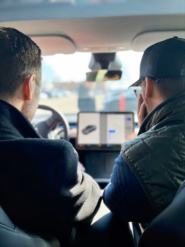 A couple of men sitting in a car.