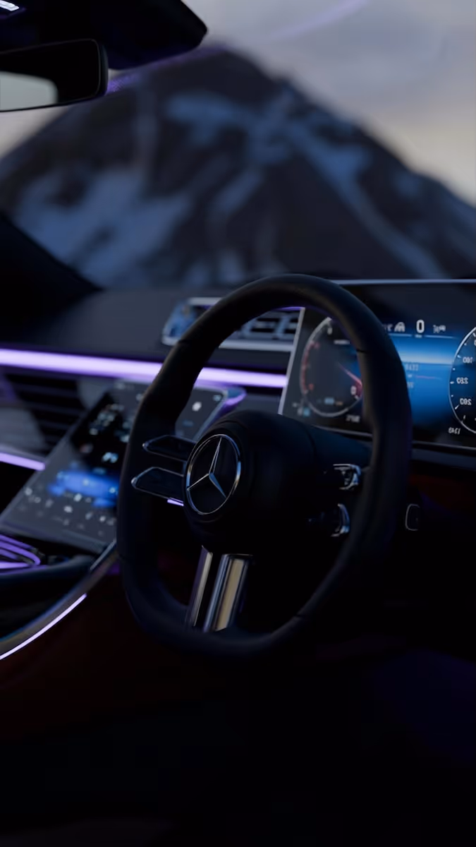 A dashboard of a car with a mountain in the background.