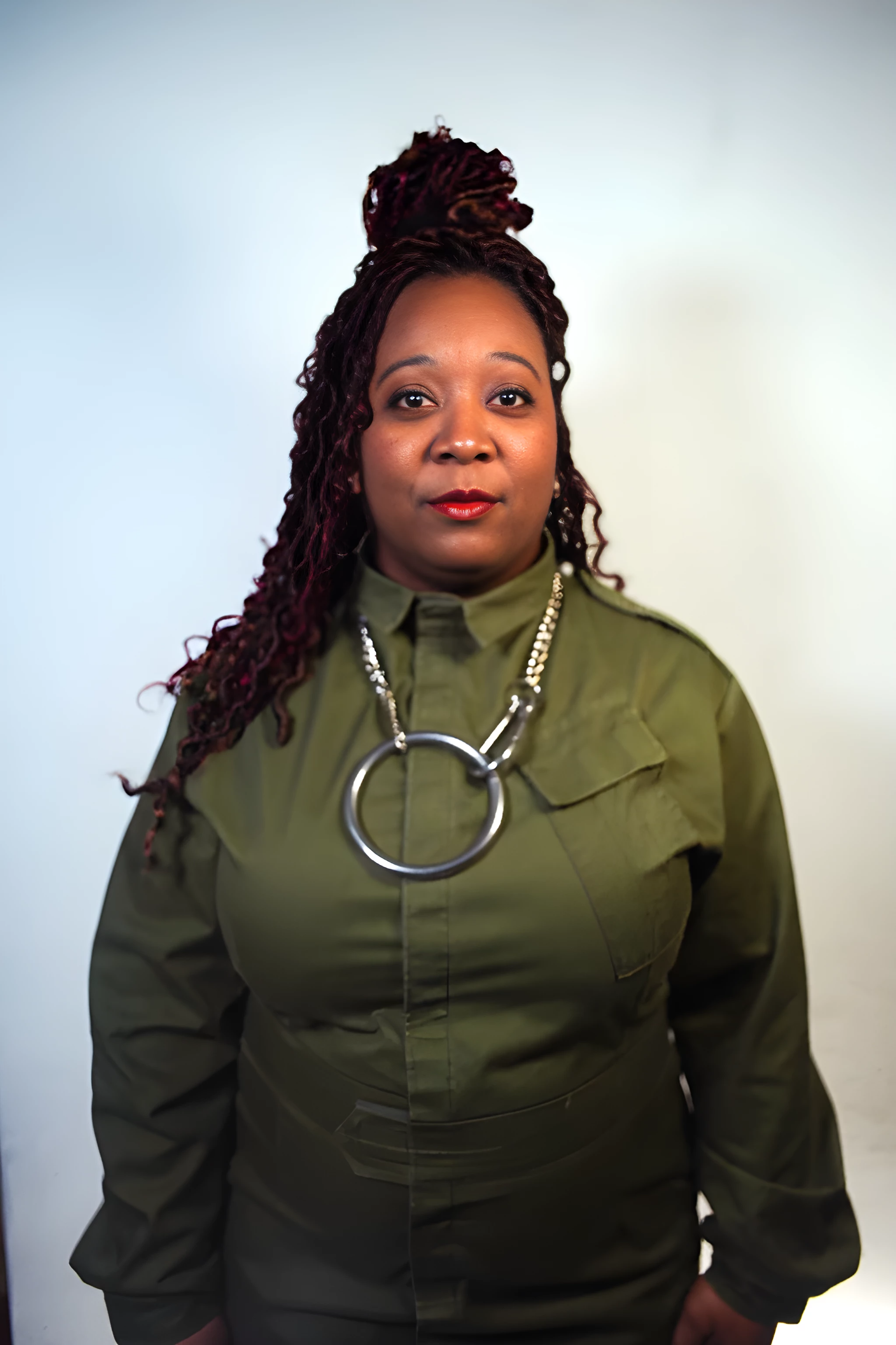 Sky Deep portrait in green jumpsuit.  Photo by Claudia Hampton