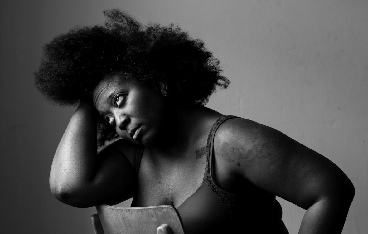 A professional black and white portrait of Sky Deep looking thoughtfully downward. Photo by Alexa Vachon