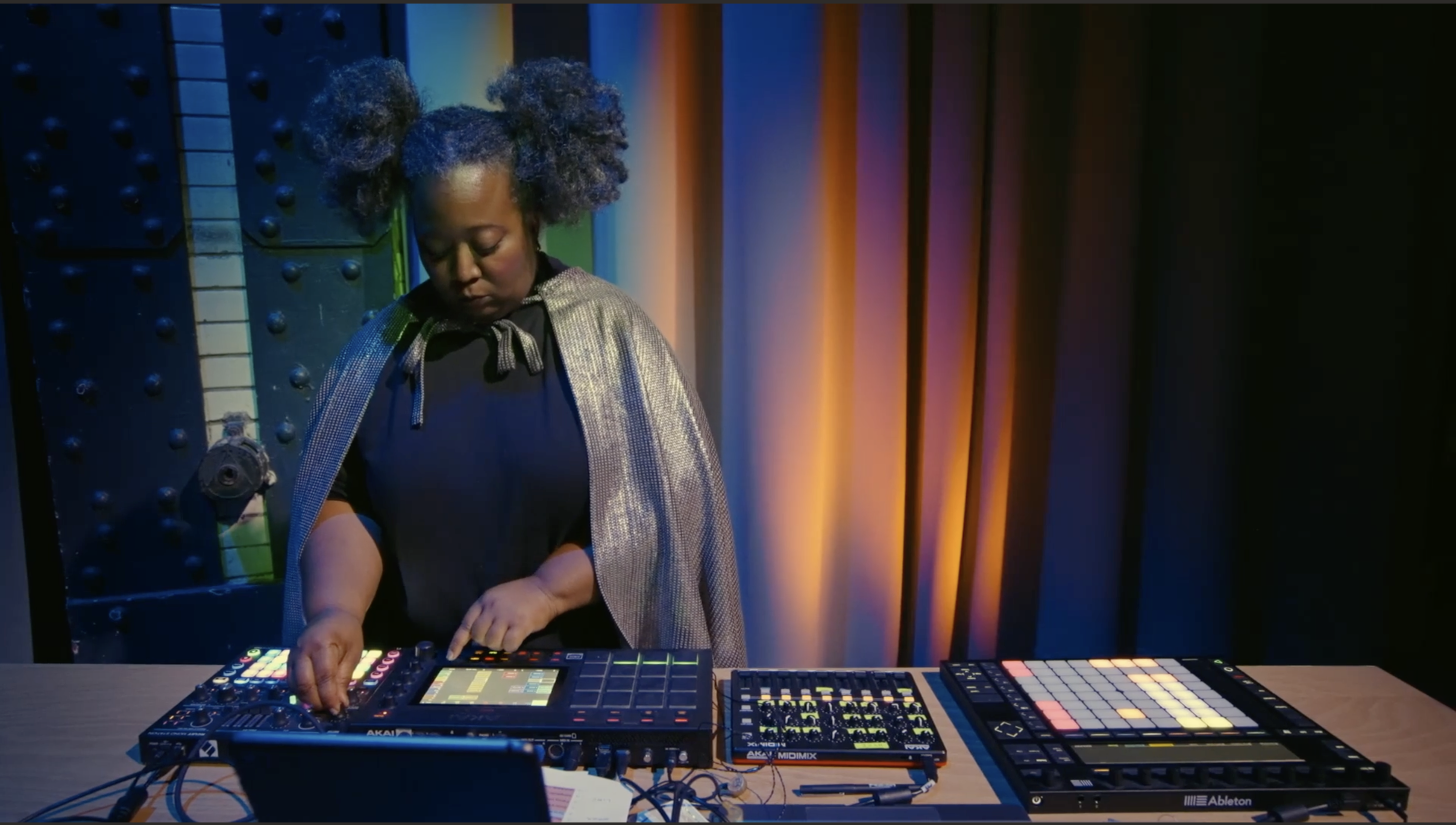Sky Deep performing a live electronic music set with a hardware controller and MPC setup.