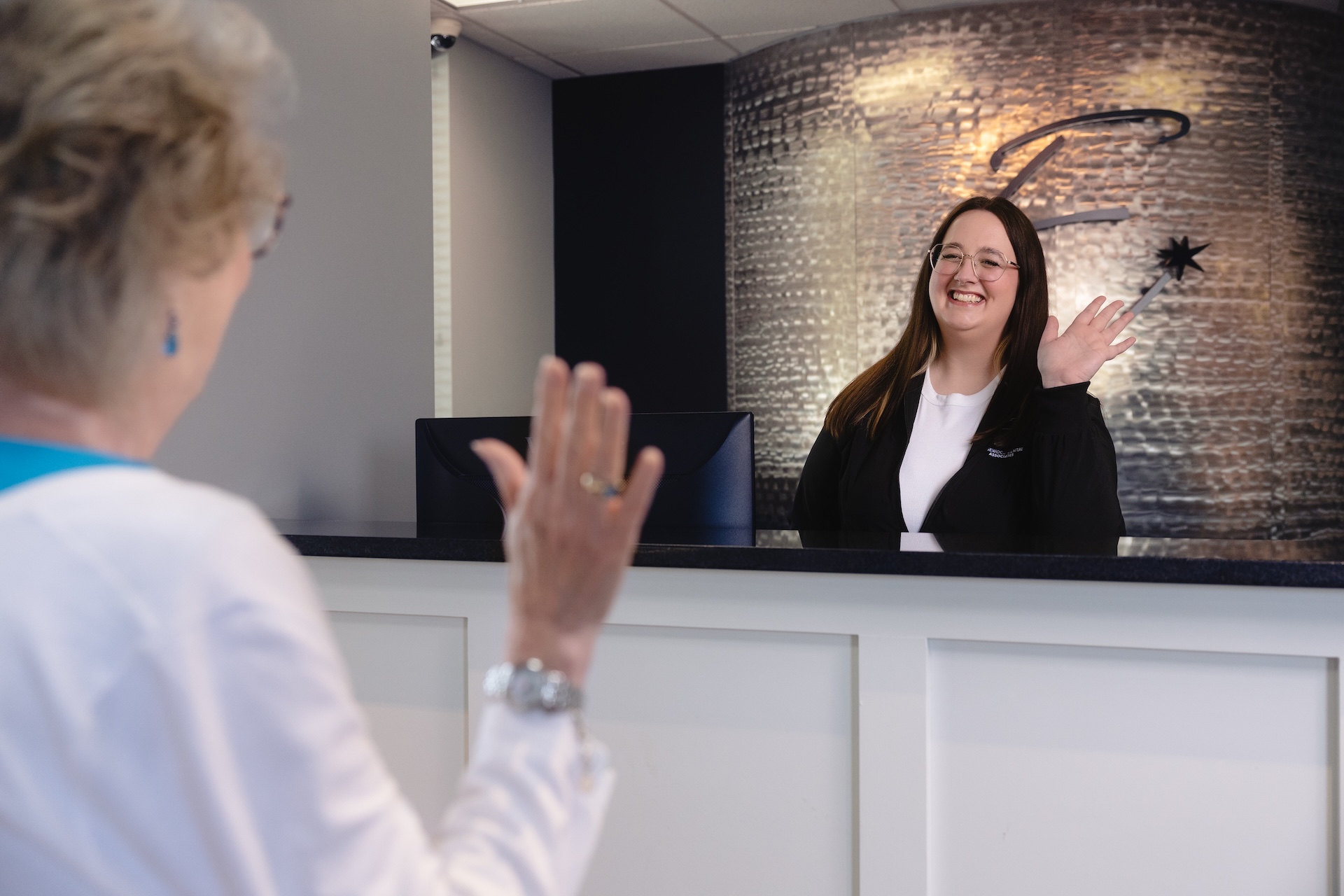 Our welcoming reception team smiling at a new patient