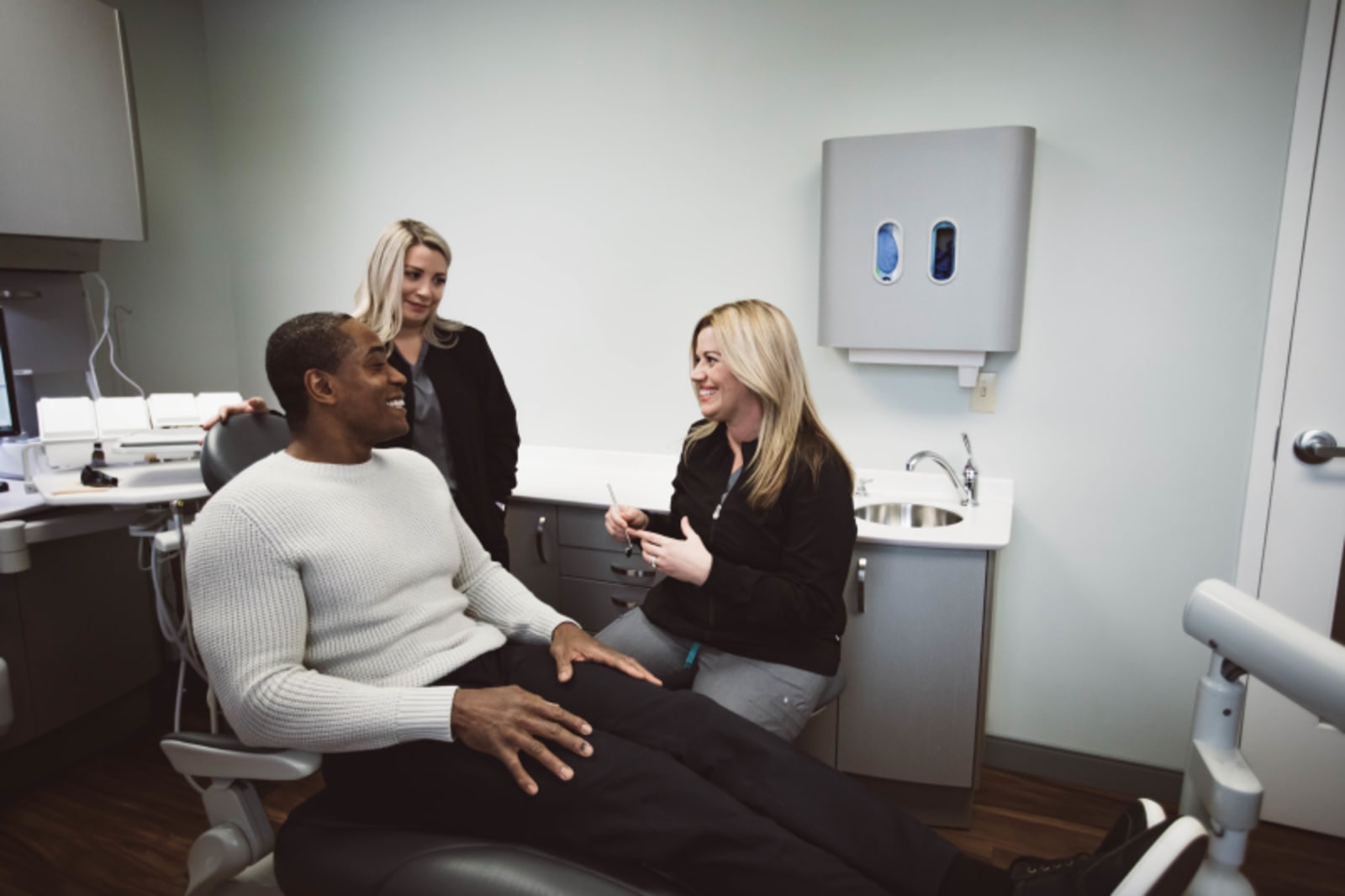Dentist discussing implant procedure with patient in clinical treatment room at Edgewood Dental Associates.