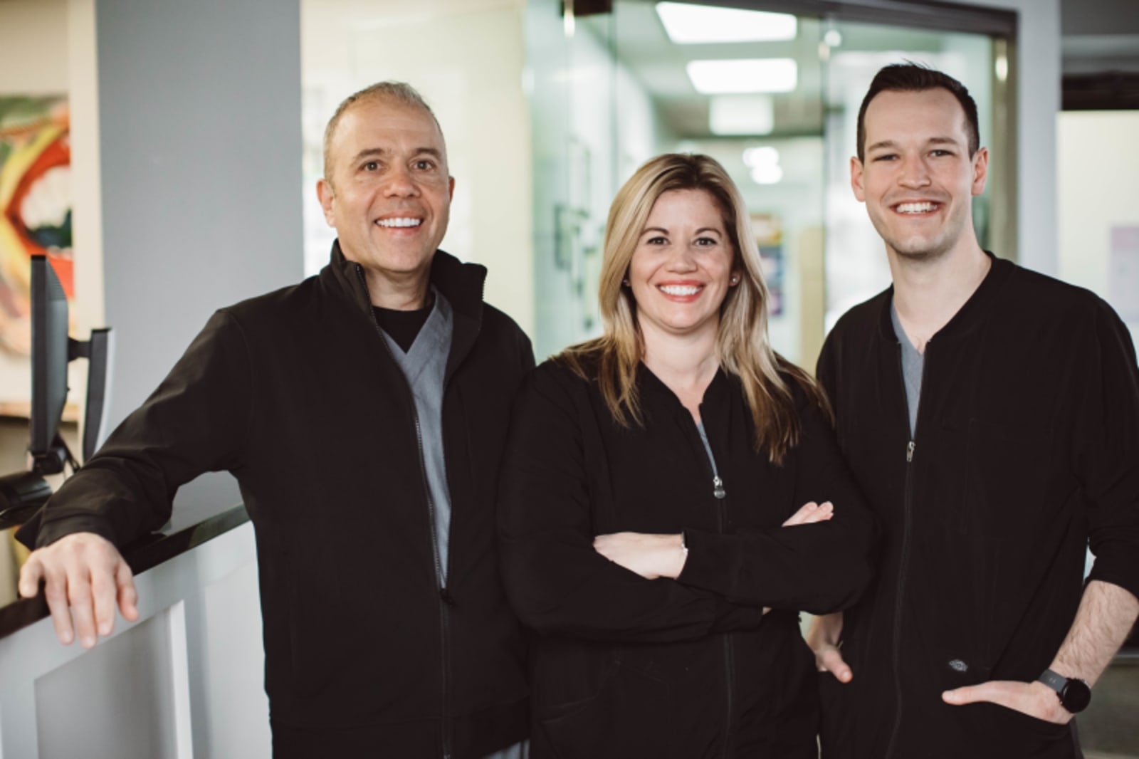 Three team members from Edgewood Dental smiling together in office