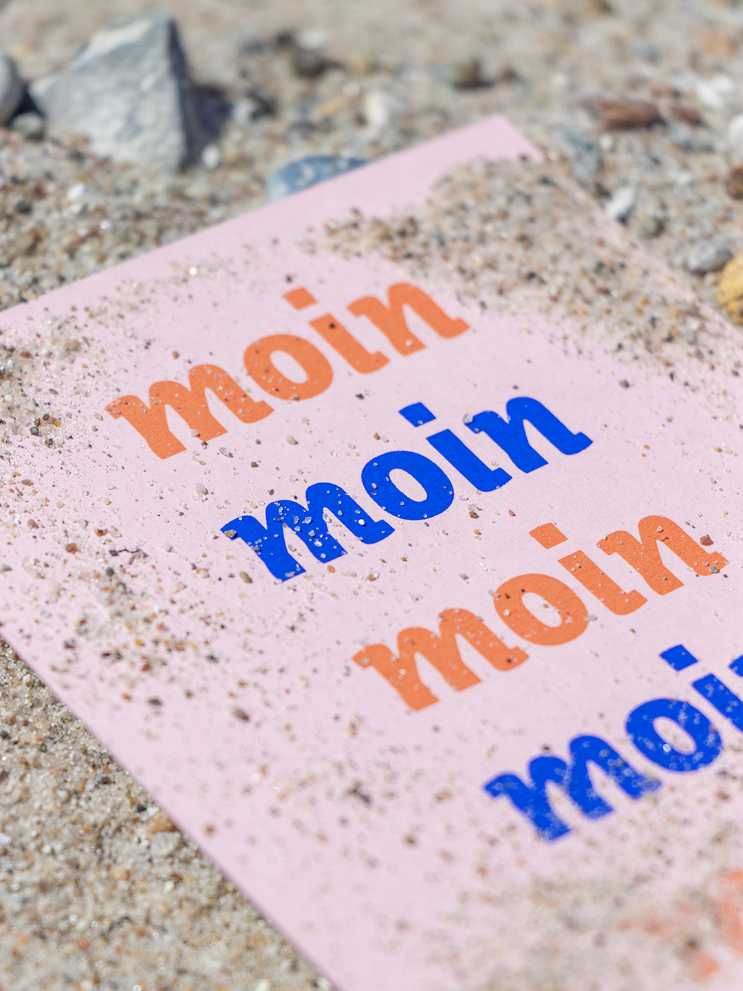 Nahaufnahme Postkarte mit Moin im Sand