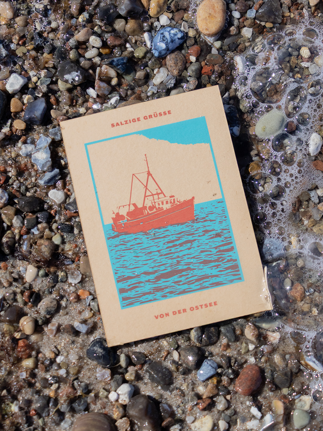 Postkarte mit einem zweifarbigen Druck eines Fischkutters mit dem Text »Salzige Grüße von der Ostsee«