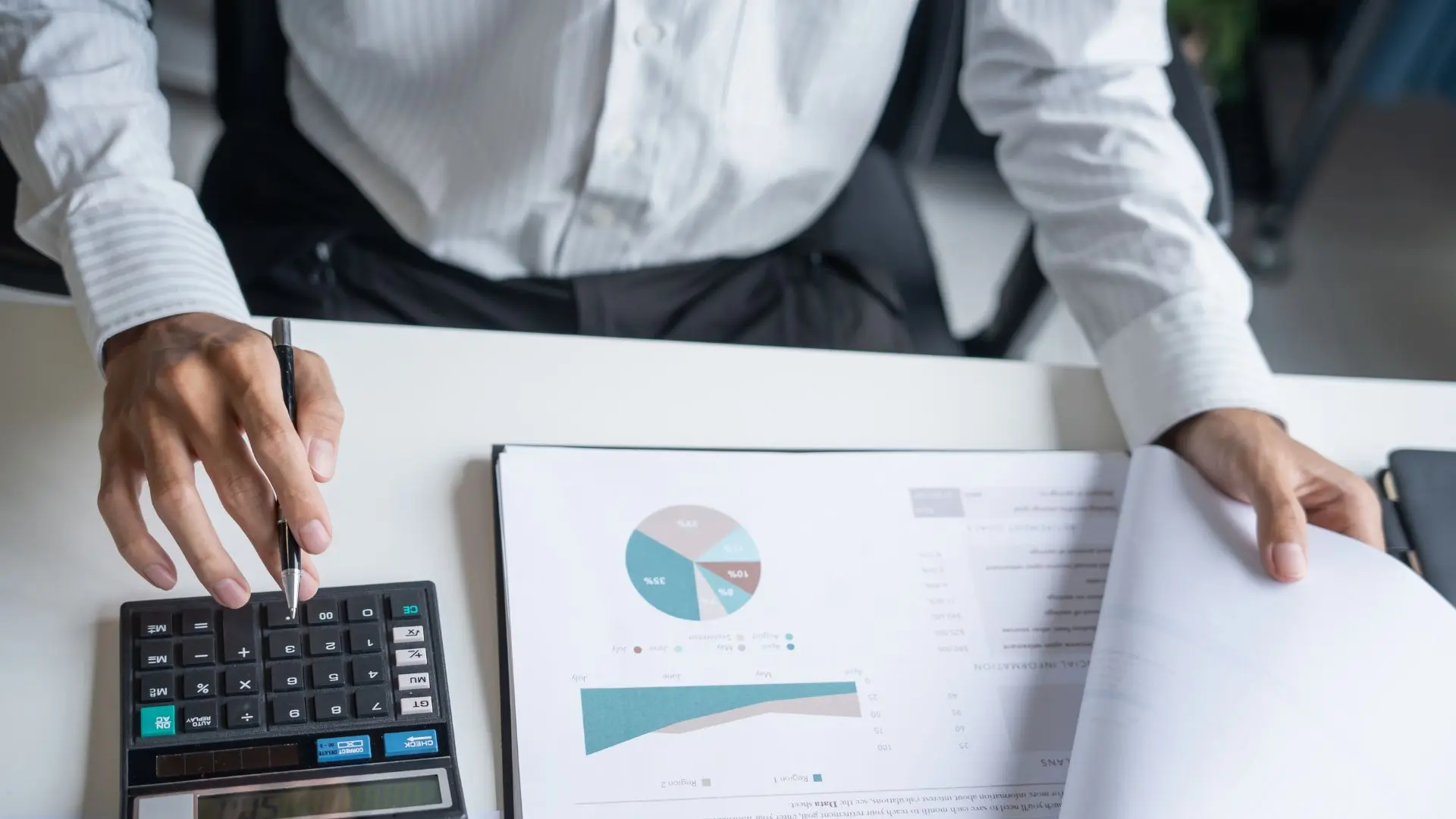 Person im Büro bei der Auswertung von Umsatzdiagrammen, Berichten und Finanzkennzahlen
