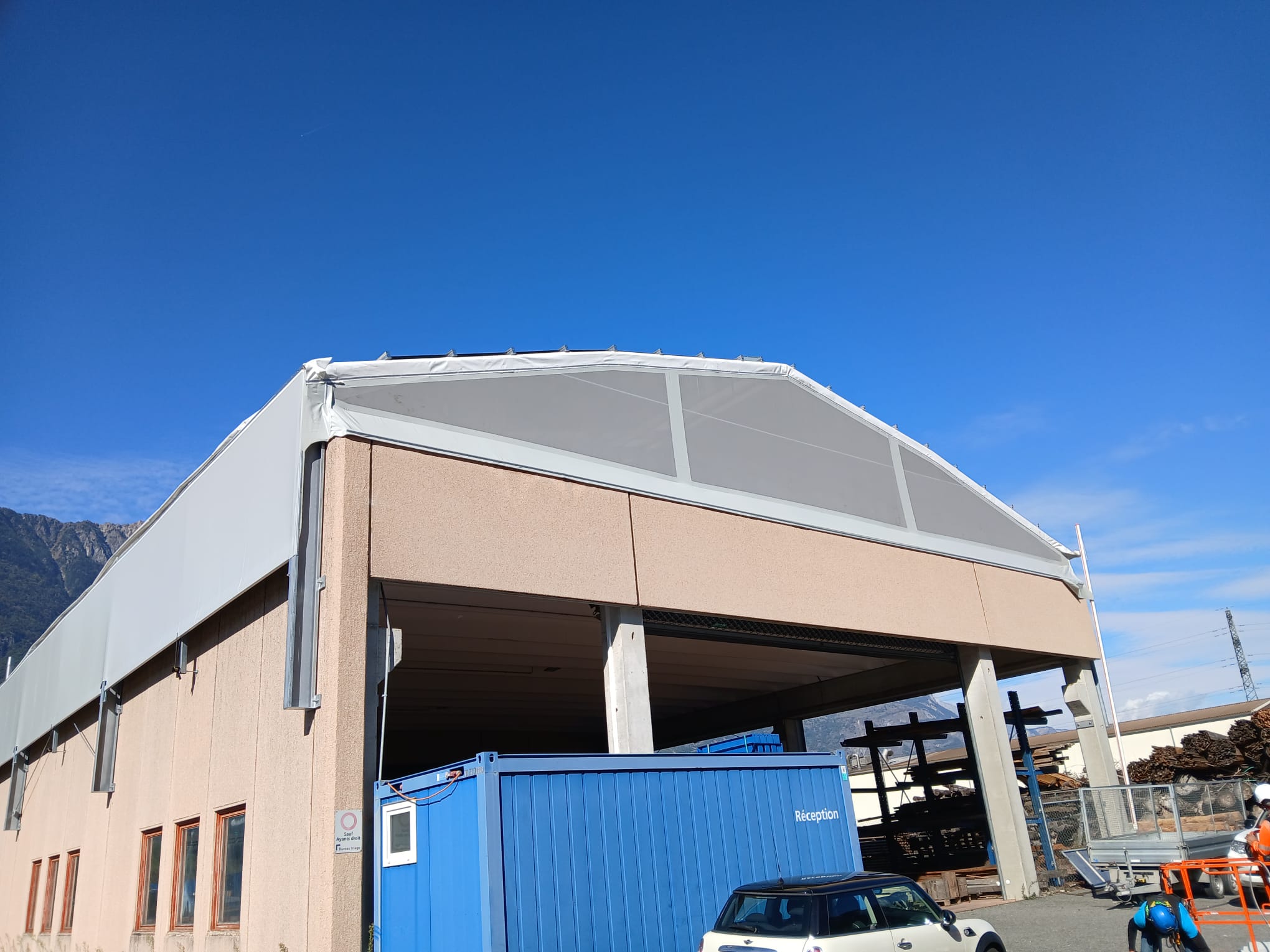 Installation et tension d'une membrane sur les côtés d'un bâtiment