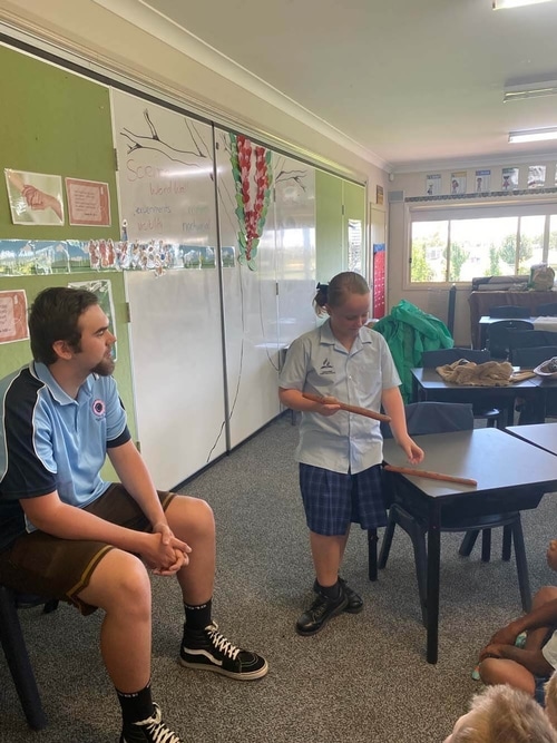 Khan Barnes helping a school student present