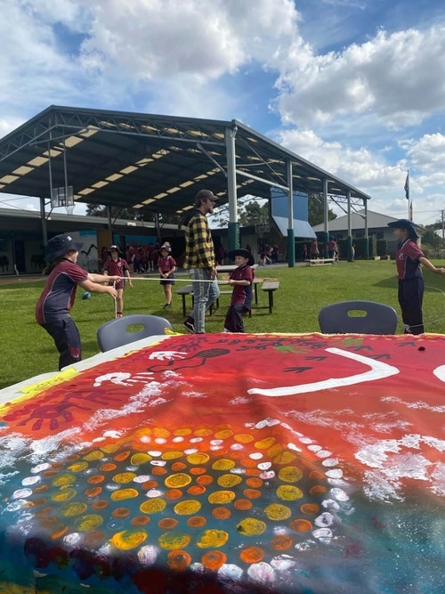 Khan Barnes watching over a group of school kids playing