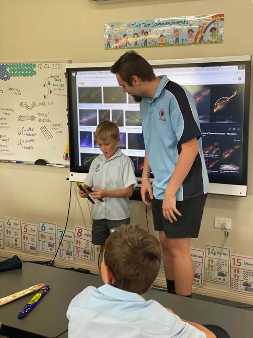 Khan Barnes helping a school student present