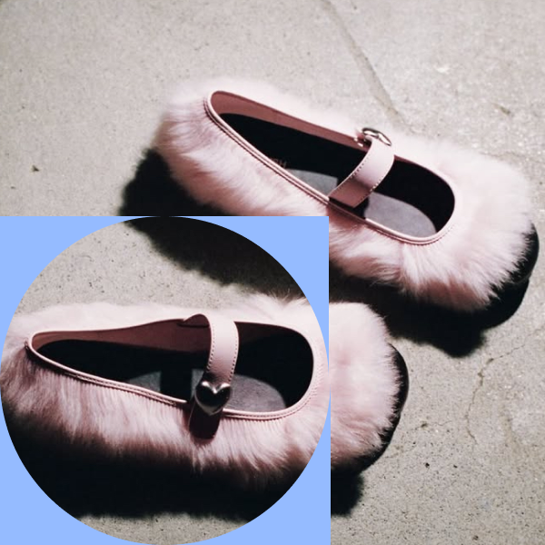 A pair of pale pink Mary Jane flats from the UGG × AMBUSH collaboration, trimmed in long shearling and photographed on concrete, with a close-up of the heart-shaped strap buckle.
