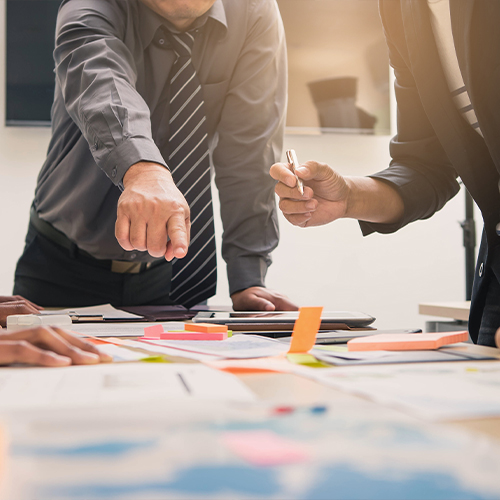 Image of people gathered around a table with papers and folders. On top of the image there are 4 screenshots from Cooleaf featuring their engagement strategy recommended program plan.
