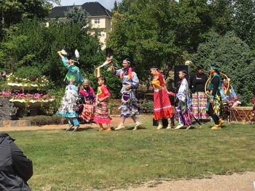Native dancers with their ribbon and bell dresses in bright colours perform