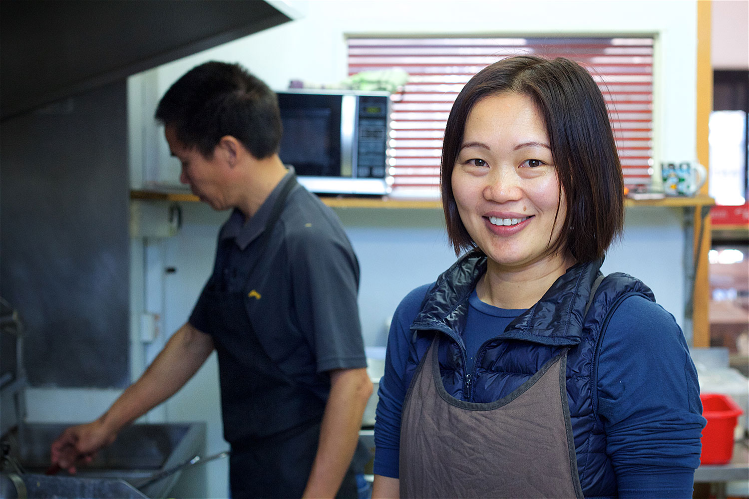 Two workers stand in a takeaway shop