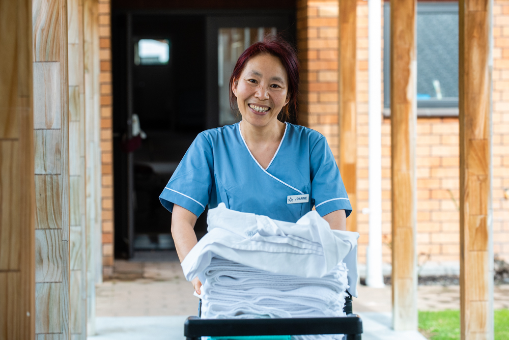 Worker standing outside with laundry