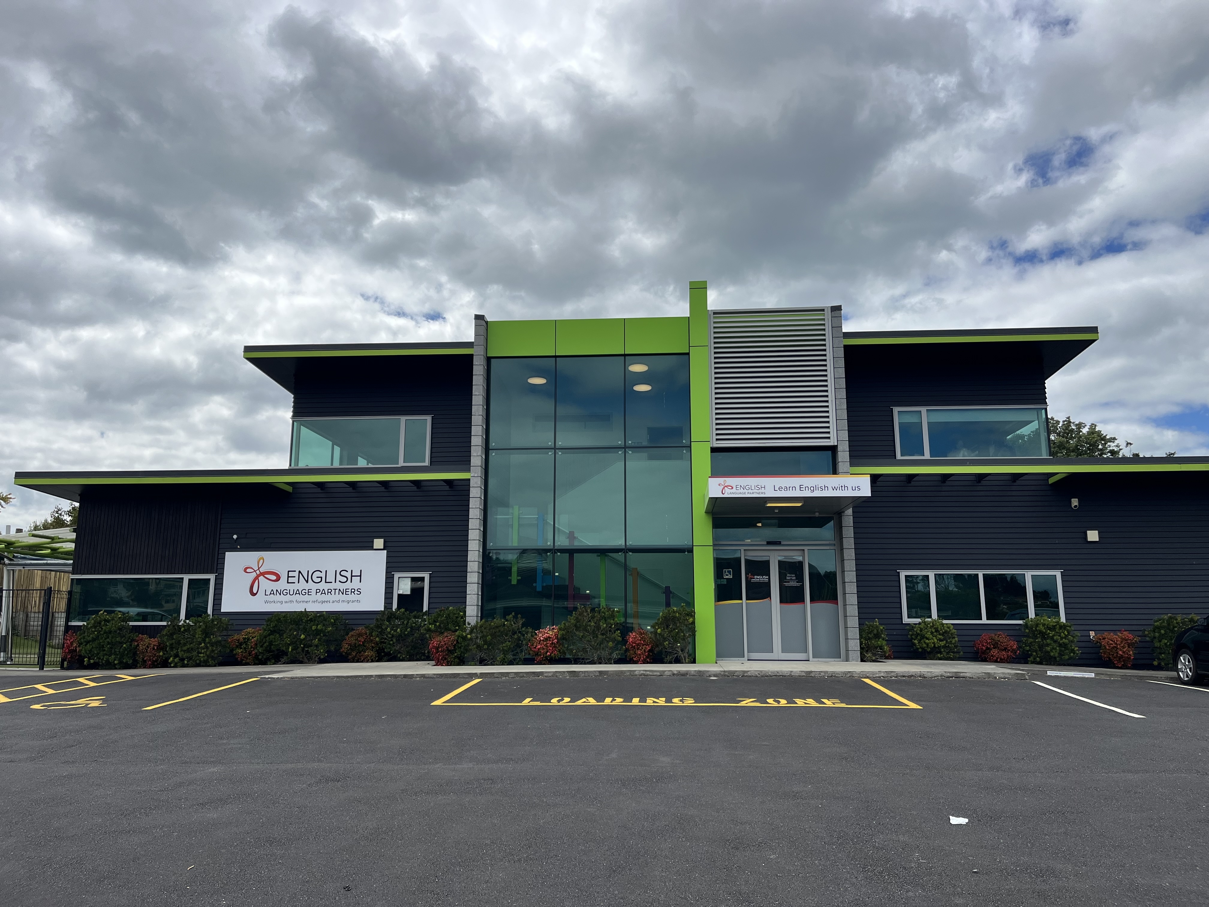 The outside of the building showing two floors, the car park and signage for English Language Partners North Shore 
