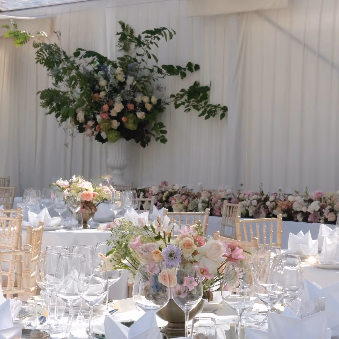 Bordsdekor bröllop och blomsterdekoration på piedestal bakom honnörsbord