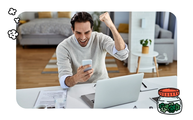 Excited man pumps fist while reading an email on his smartphone about winning a cannabis business license