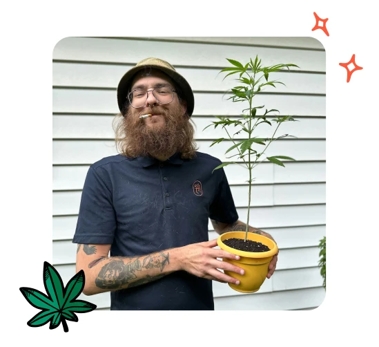 A photo of Alex Penwitt holding a cannabis plant, one of the Budtender Spotlight winners.