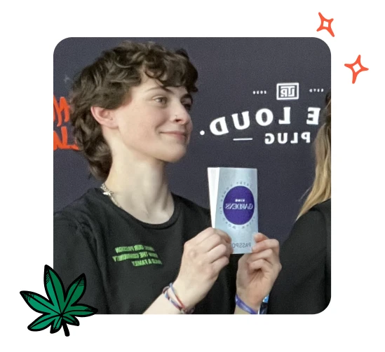 Adrianna Curnew from Plantlife dispensary is smiling while holding up an object.