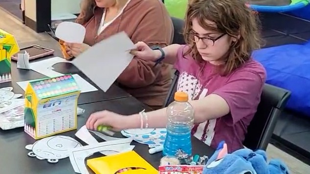 Teen participant taking part in a crafts activity in NAC’s Skills and Recreation Program.
