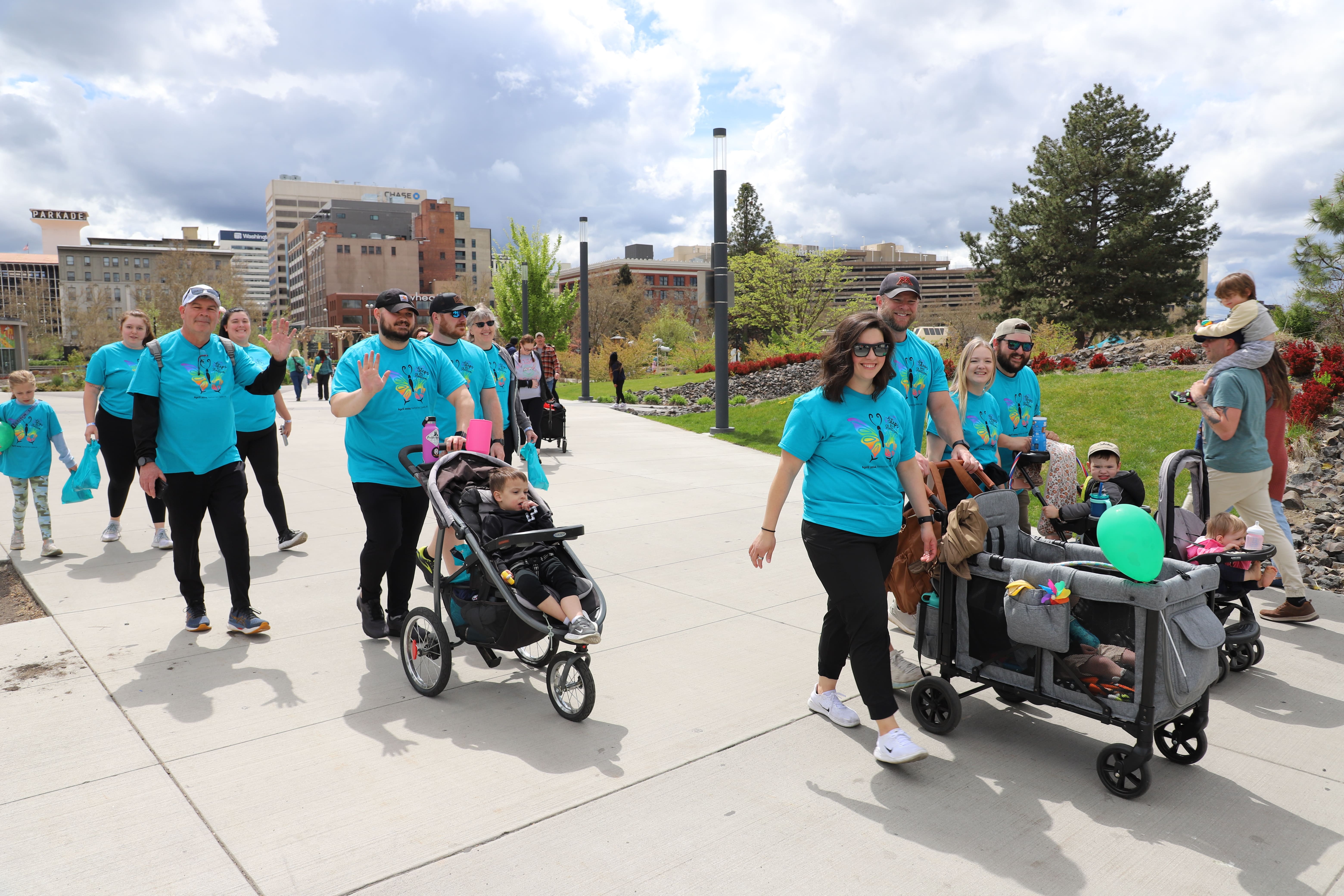 Group of participants wearing matching shirts walk together outdoors during NAC’s annual Steps for Autism community event.