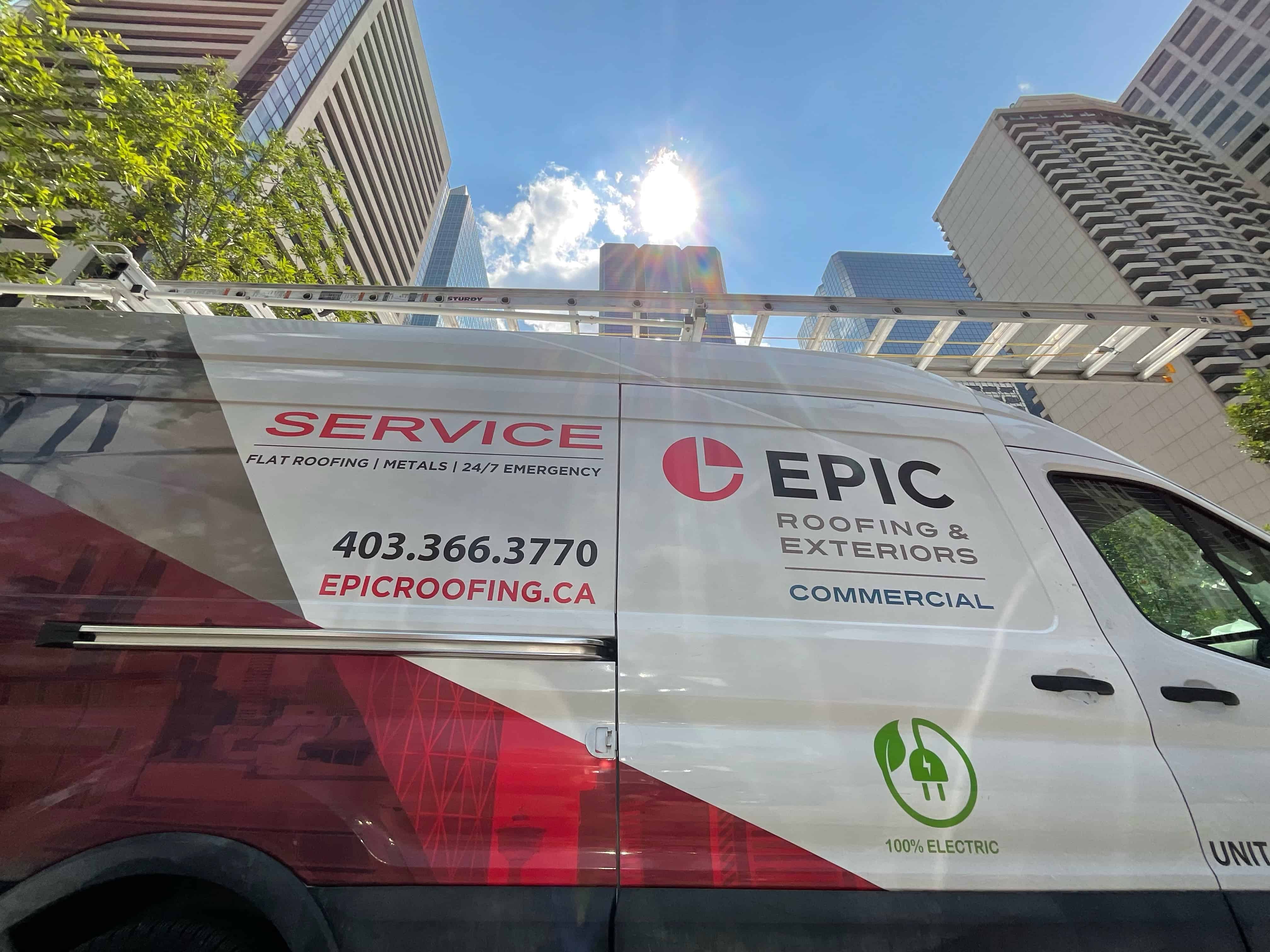 A white commercial van with the logo and branding of 'EPIC Roofing & Exteriors', parked on a street with high-rise buildings in the background.