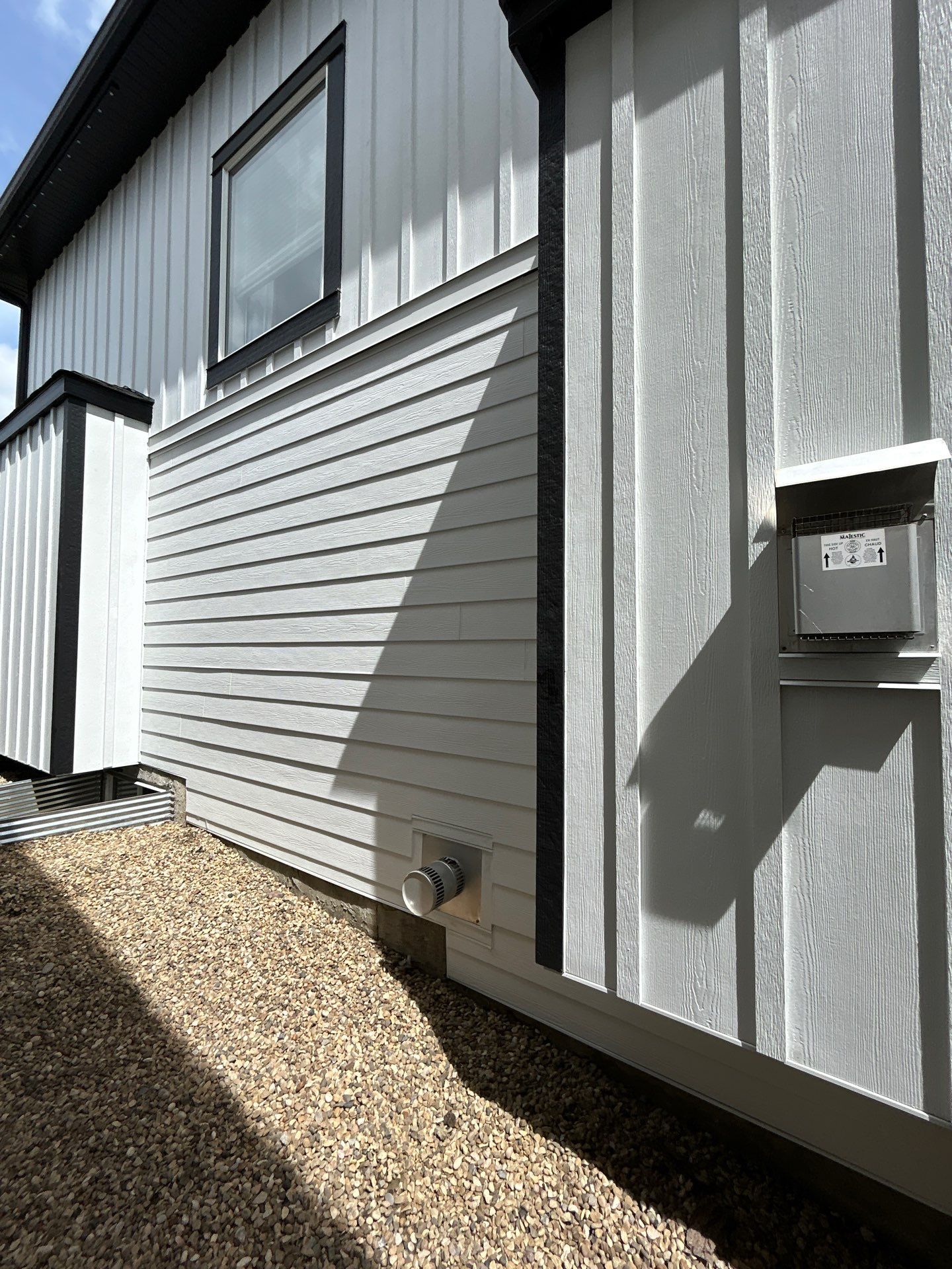 Home exterior finished with white James Hardie lap and board-and-batten siding with black trim.