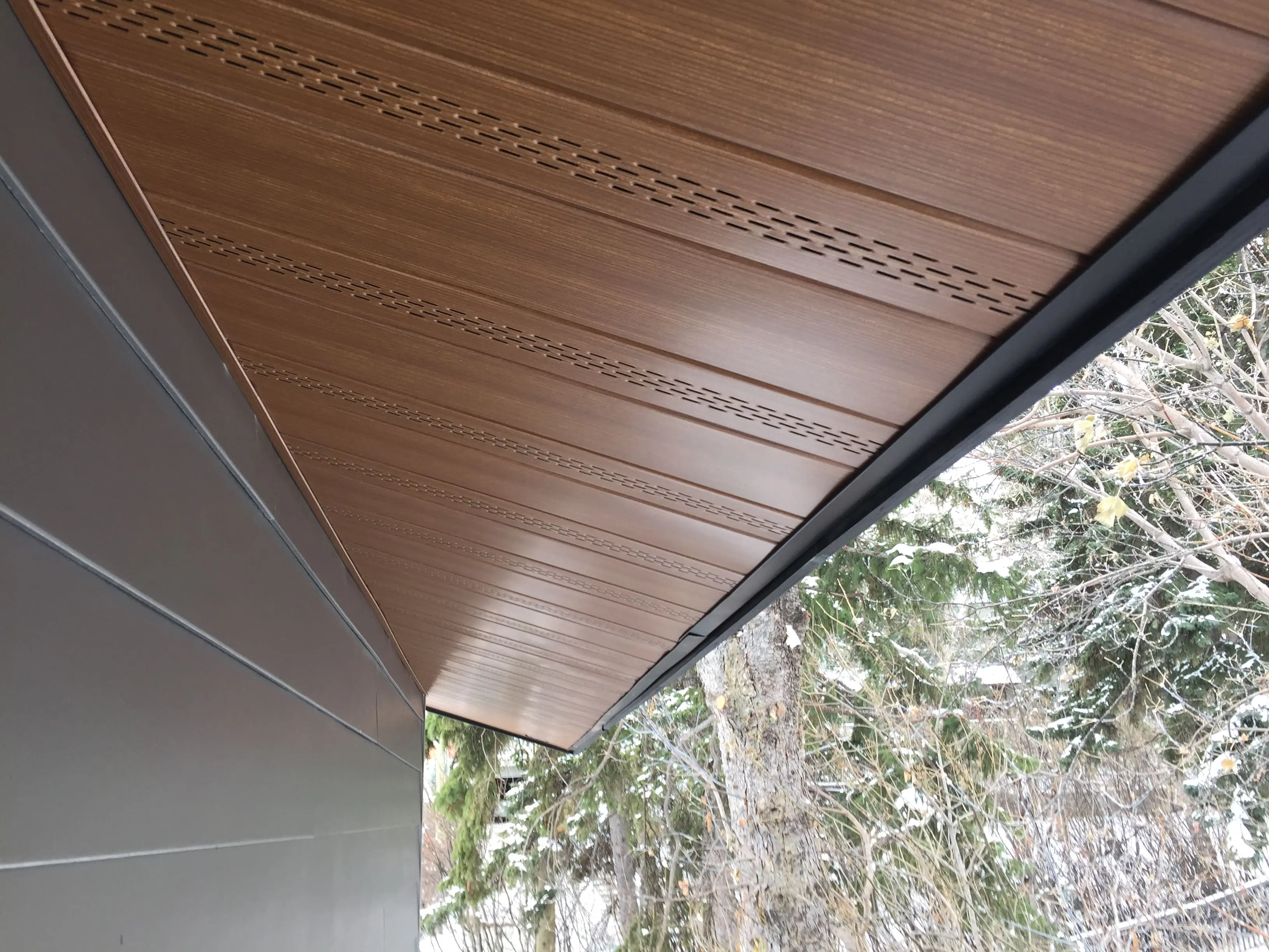 Wood-look vented soffit installed beneath a roof overhang.