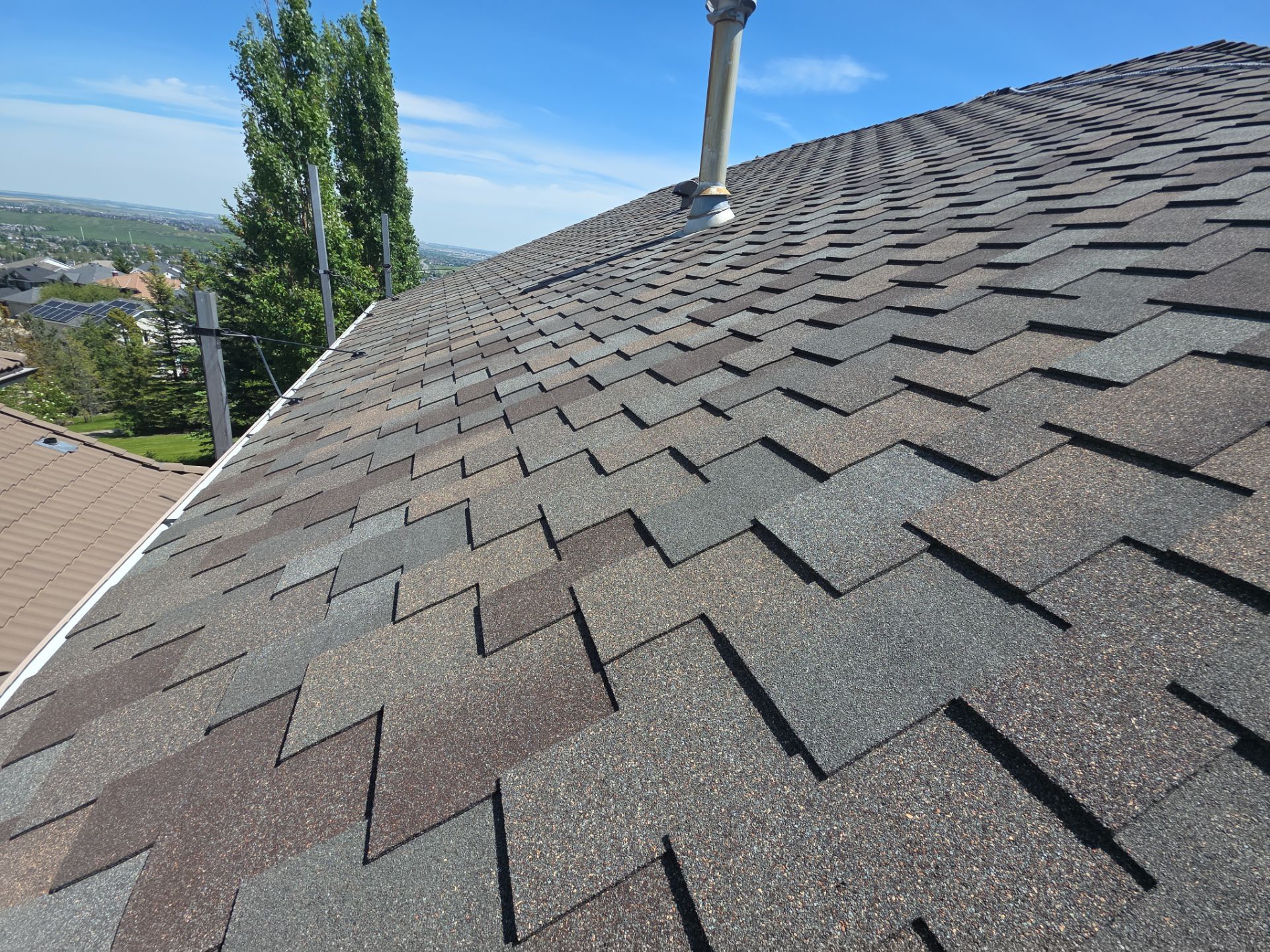 Angle view looking up a steep roof with new asphalt shingles.