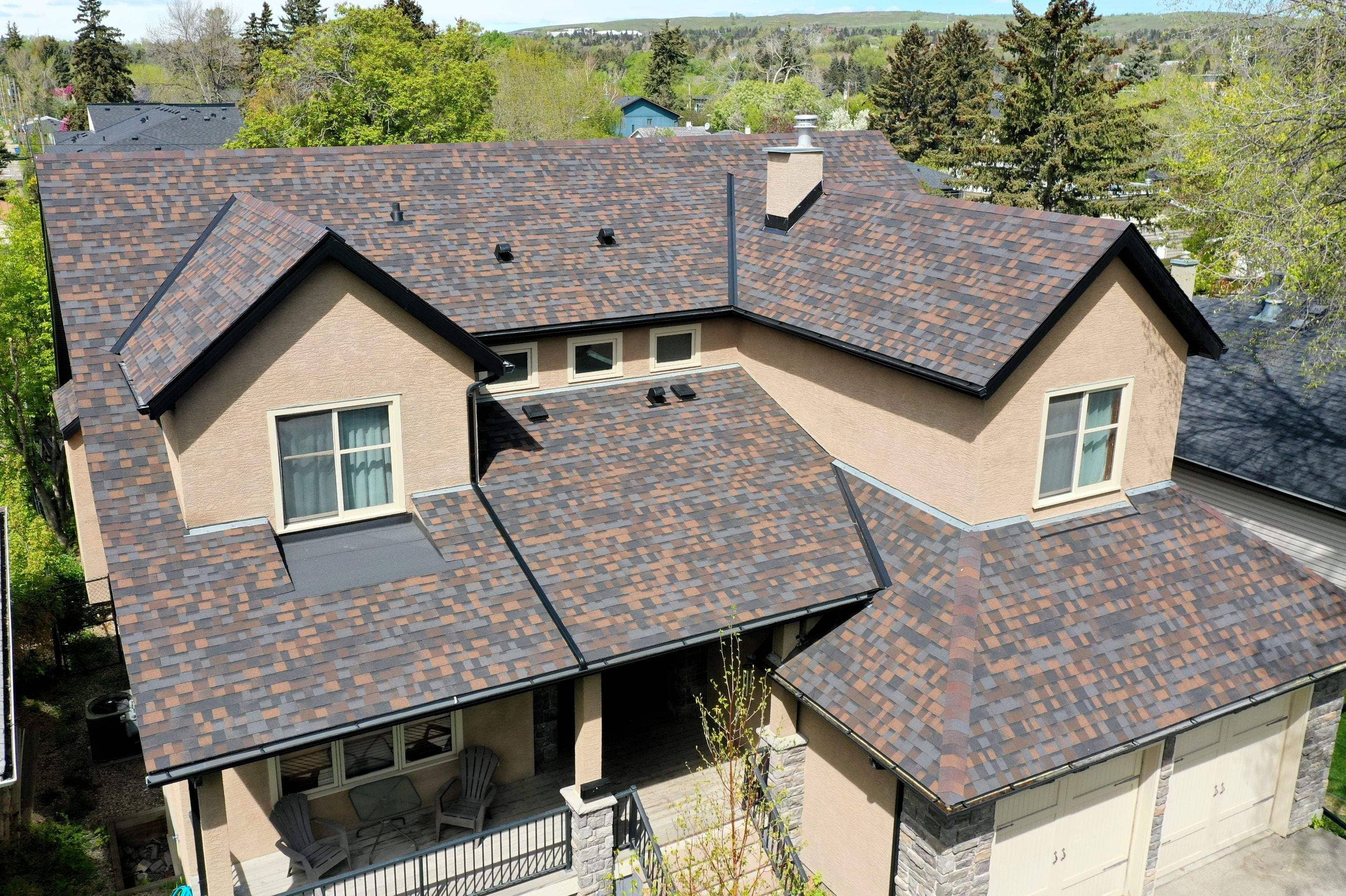 Aerial view of a beige house with brown asphalt shingles.