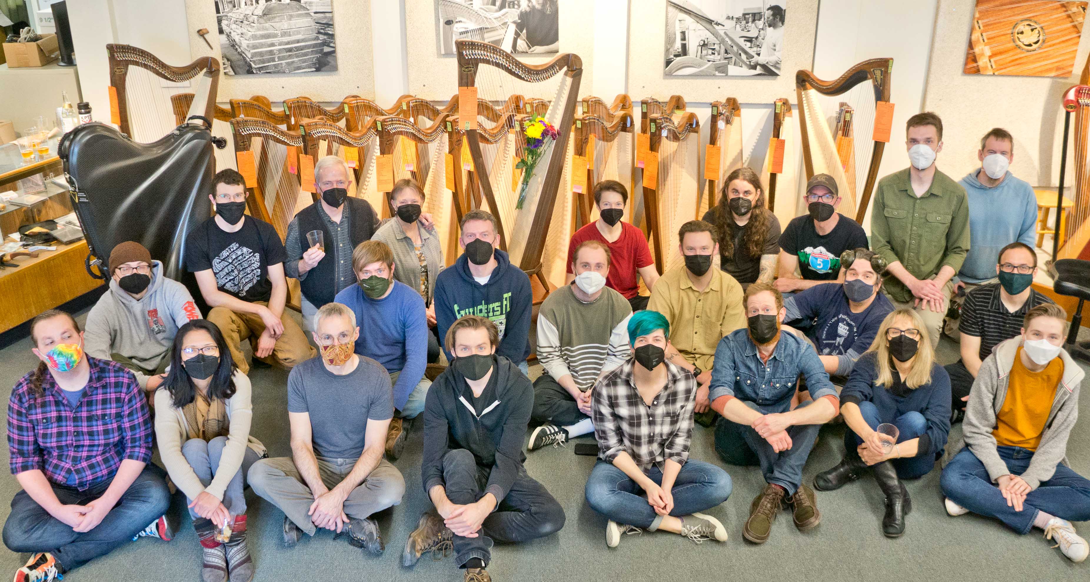 The Dusty Strings manufacturing team posing for a group photo in front of a final FH34S and around 20 prototypes.
