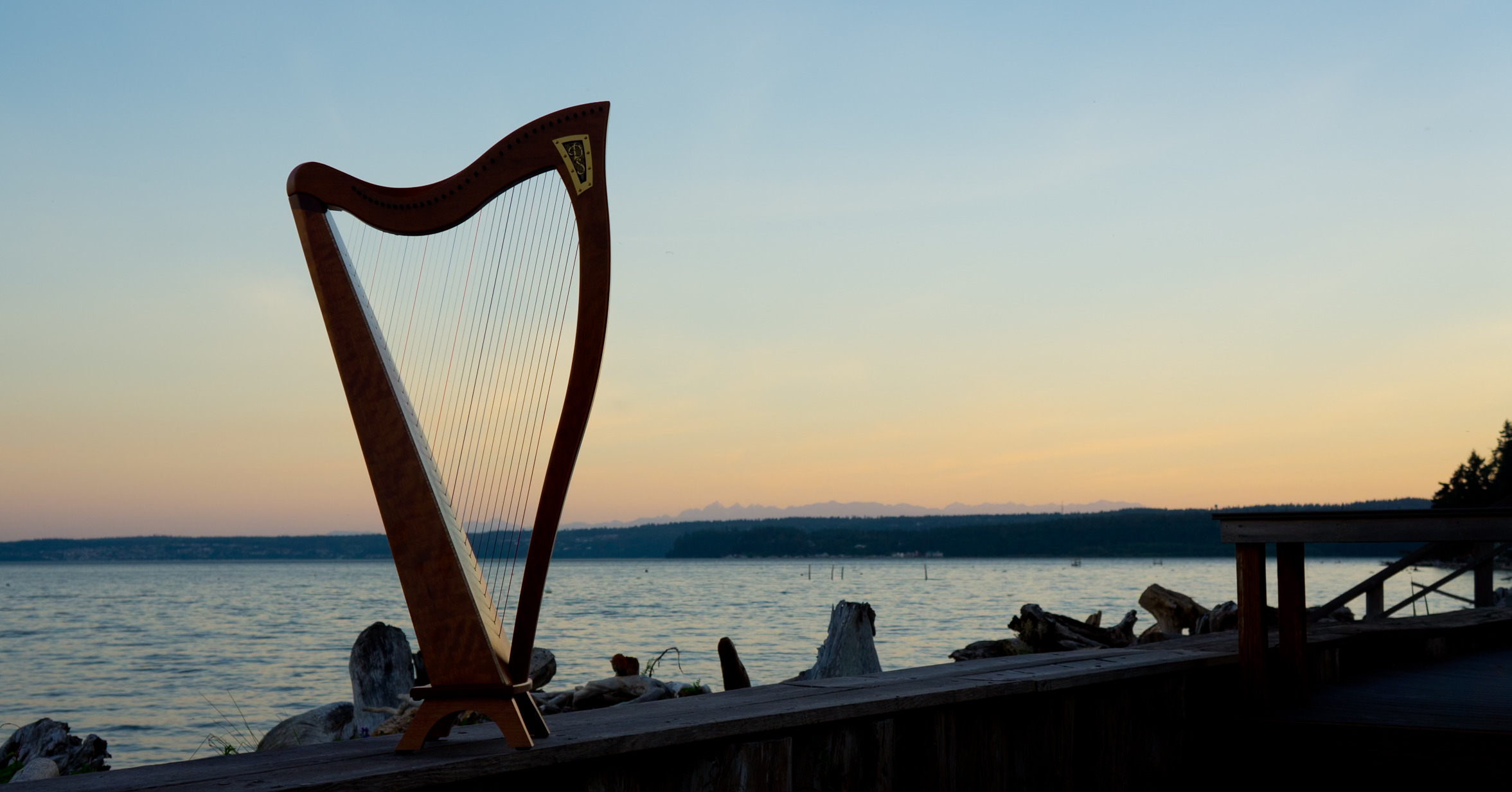 Dusty Strings FH4 harp silhouetted against an ocean sunset