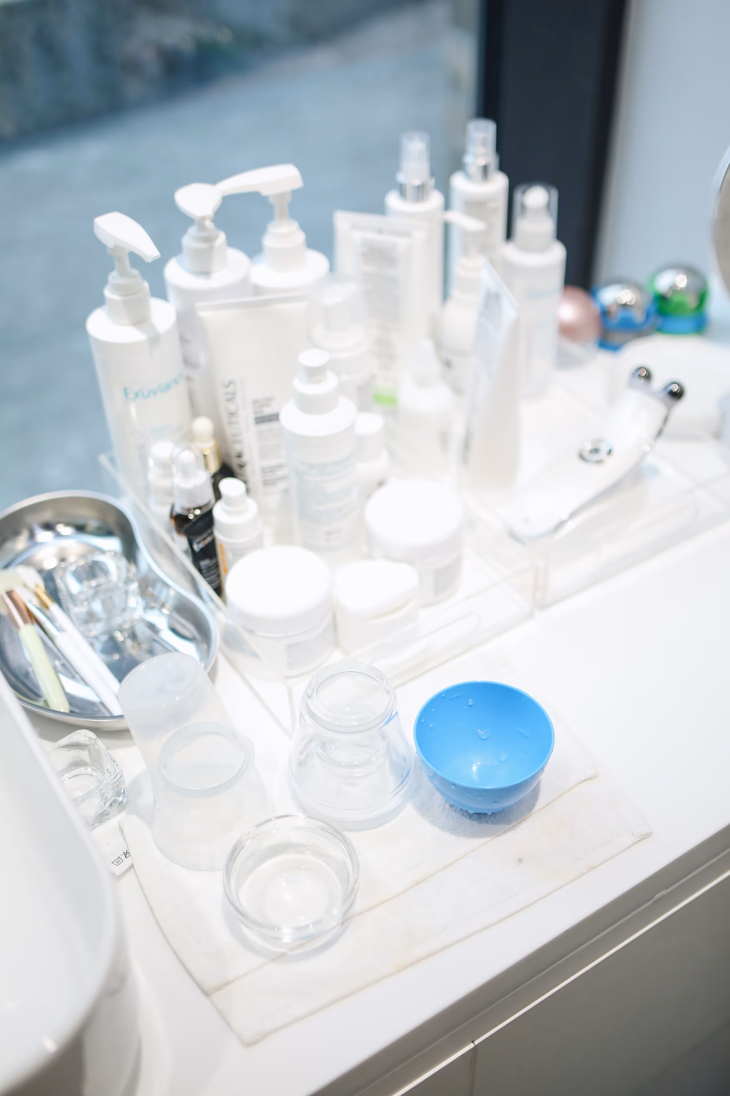 Numerous white dispensers, bottles and tubes in a bathroom