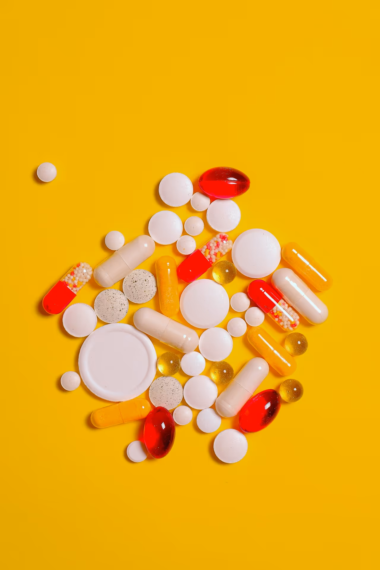 Assortment of pills against a yellow background
